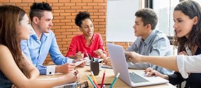 Multiethnic group of professionals collaborating around a table, representing regional Centres of Vocational Excellence connecting education and business